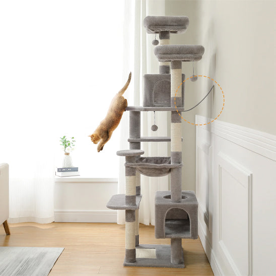 Arbre Ă chat multifonctionnel gris avec hamac, niche et griffoir avec un chat roux qui saute de cet arbre.
