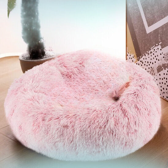Coussin chat de couleur rose clair en peluche douce avec un chat blanc assis dedans.