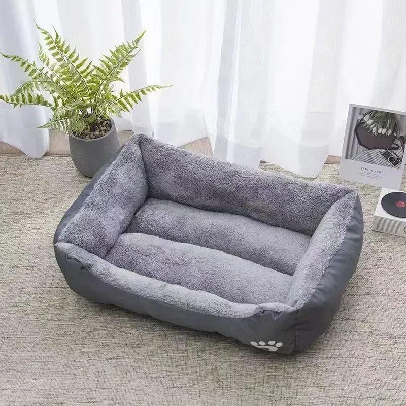 Lit pour chat rectangulaire gris foncé et peluche grise à l'intérieur.