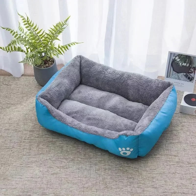 Lit pour chat rectangulaire bleu et peluche grise à l'intérieur.