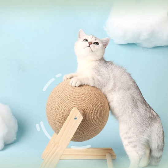 Griffoir à chat en bois en forme de V et L avec une boule en sisal et un chat gris qui joue avec la boule.