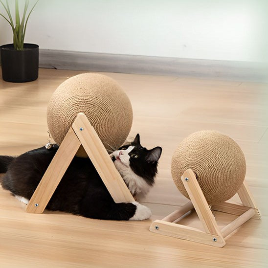 Griffoir à chat en bois en forme de V et L avec une boule en sisal et un chat noir qui joue avec.