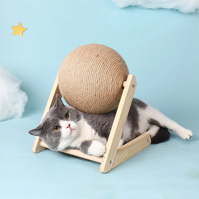 Griffoir à chat en bois en forme de V et L avec une boule en sisal et un chat gris allongé dessous.