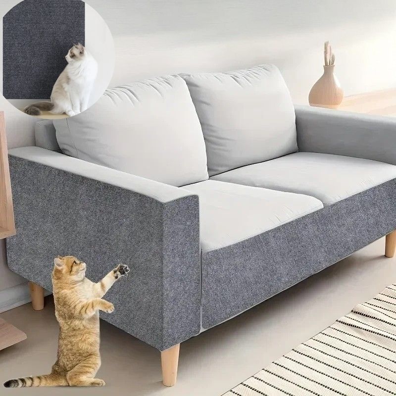 Un griffoir à chat gris foncé collé sur le tour du fauteuil de salon avec un chat assis à cÎté du fauteuil.