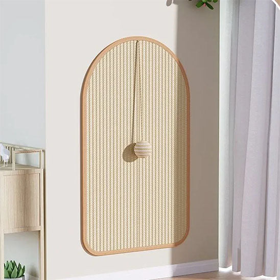 Griffoir chat en sisal et en forme de tapis carré collé sur un mur, avec une balle suspendue en sisal et un chat allongé dessus et fait ses griffes.