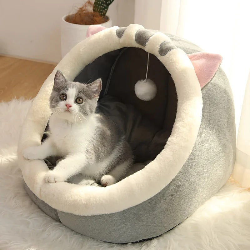 Niche pour chat en forme de chaton large et grise avec une balle suspendue et un chaton gris assis dedans.