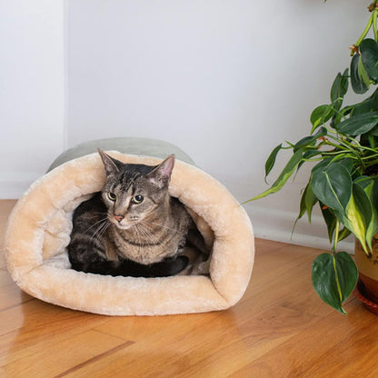 Coussin chat en forme de sac de couchage gris avec un chat gris assis dedans.