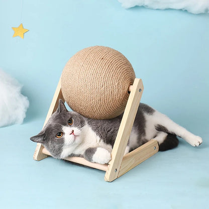 Griffoir à chat en bois en forme de V et L avec une boule en sisal et un chat gris allongé dessous.