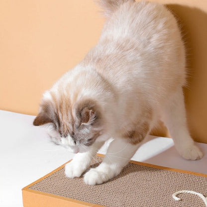 Griffoir chat carton rectangulaire petit et grand avec une souris en sisal beige collé sur l'extrémité et un chat blanc qui fait ses griffes sur ce griffoir.