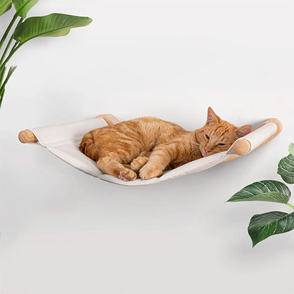 Hamac chat blanc collé au mur dans un salon et un chat roux allongé dessus confortablement.