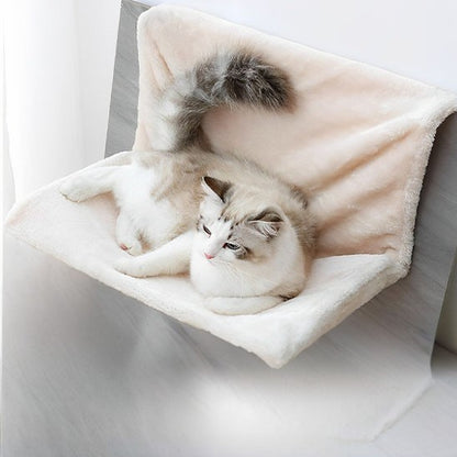 Un hamac pour chat beige placé sur un radiateur de maison avec un chat blanc et gris qui se repose dessus et en attachement, un chat roux sur un hamac placé sur le bord d'un balcon et un autre chat allongé sur un hamac gris dans une maison.