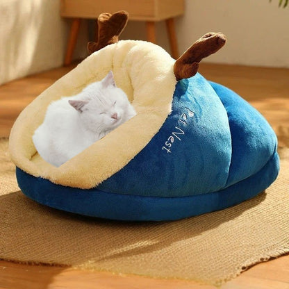 Une niche chat en forme de pantoufle bleue avec un chat blanc qui dort dedans