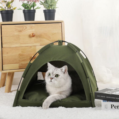 Niche chat verte en forme de tente sur un tapis blanc dans une chambre.