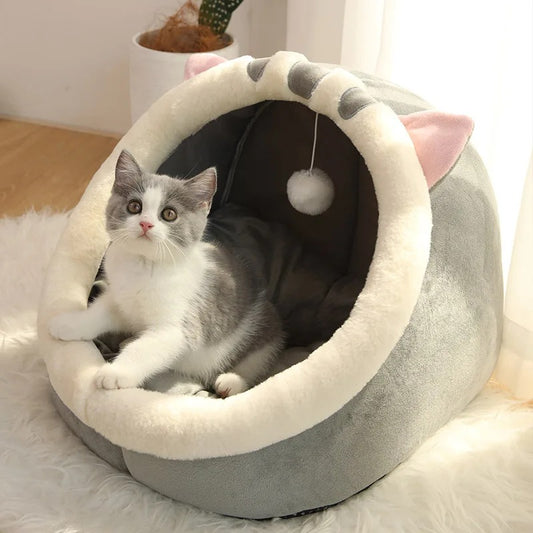 Niche pour chat en forme de chaton large et grise avec une balle suspendue et un chaton gris assis dedans.