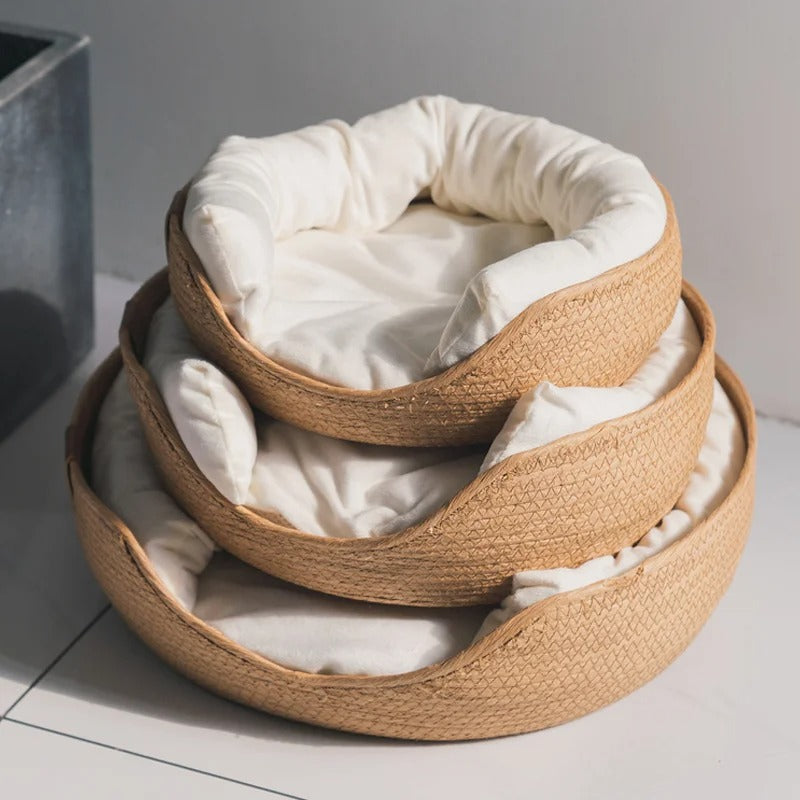 Panier osier chat beige avec un coussin blanc à l'intérieur en trois dimensions superposées.